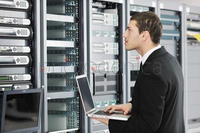 young it engeneer business man with thin modern aluminium laptop in network server room